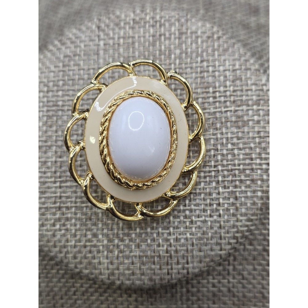 gold-tone brooch featuring a white oval cabochon center W/ cream Enamel Border